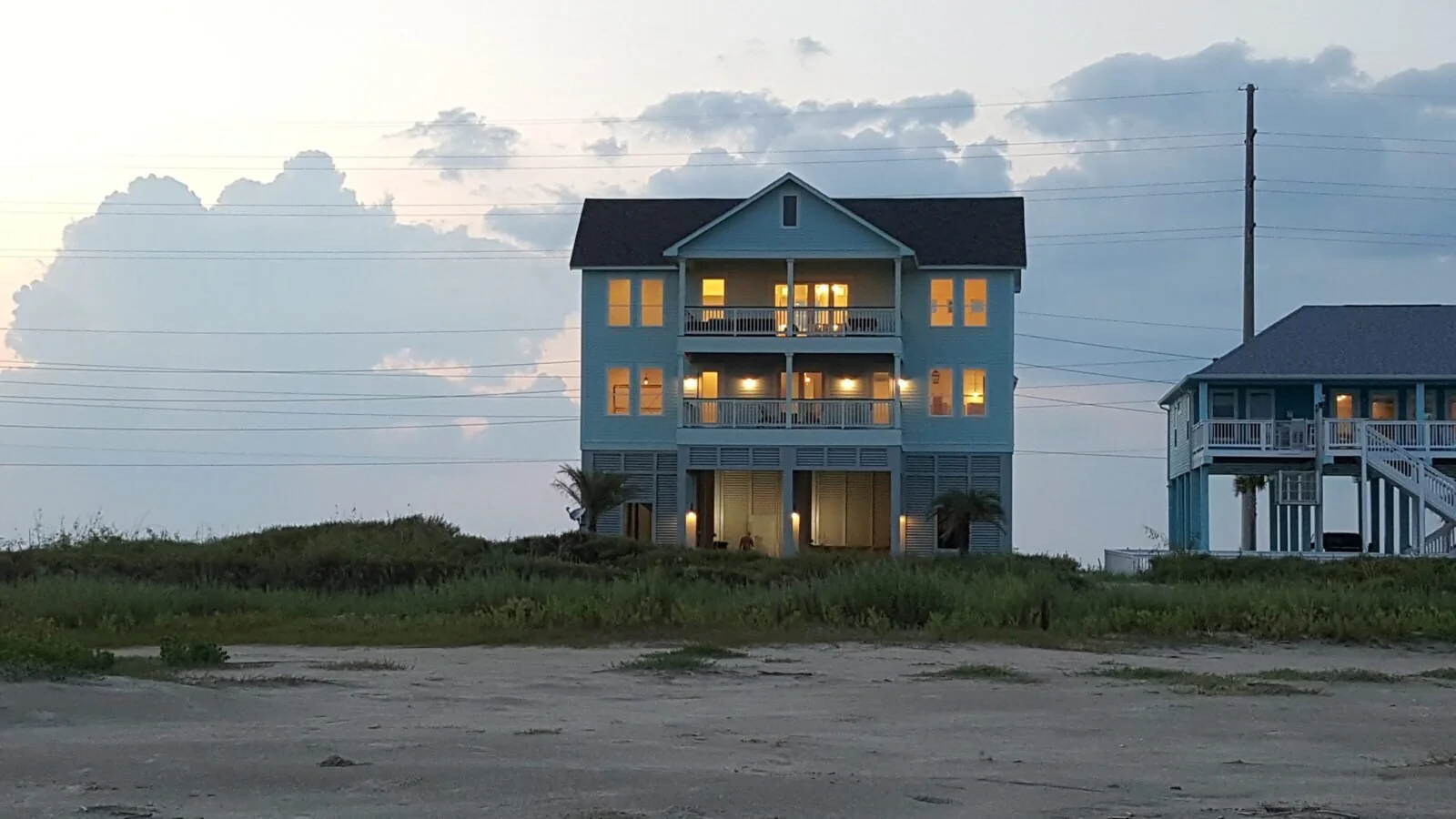 Call of the Sea beachfront home glowing at twilight