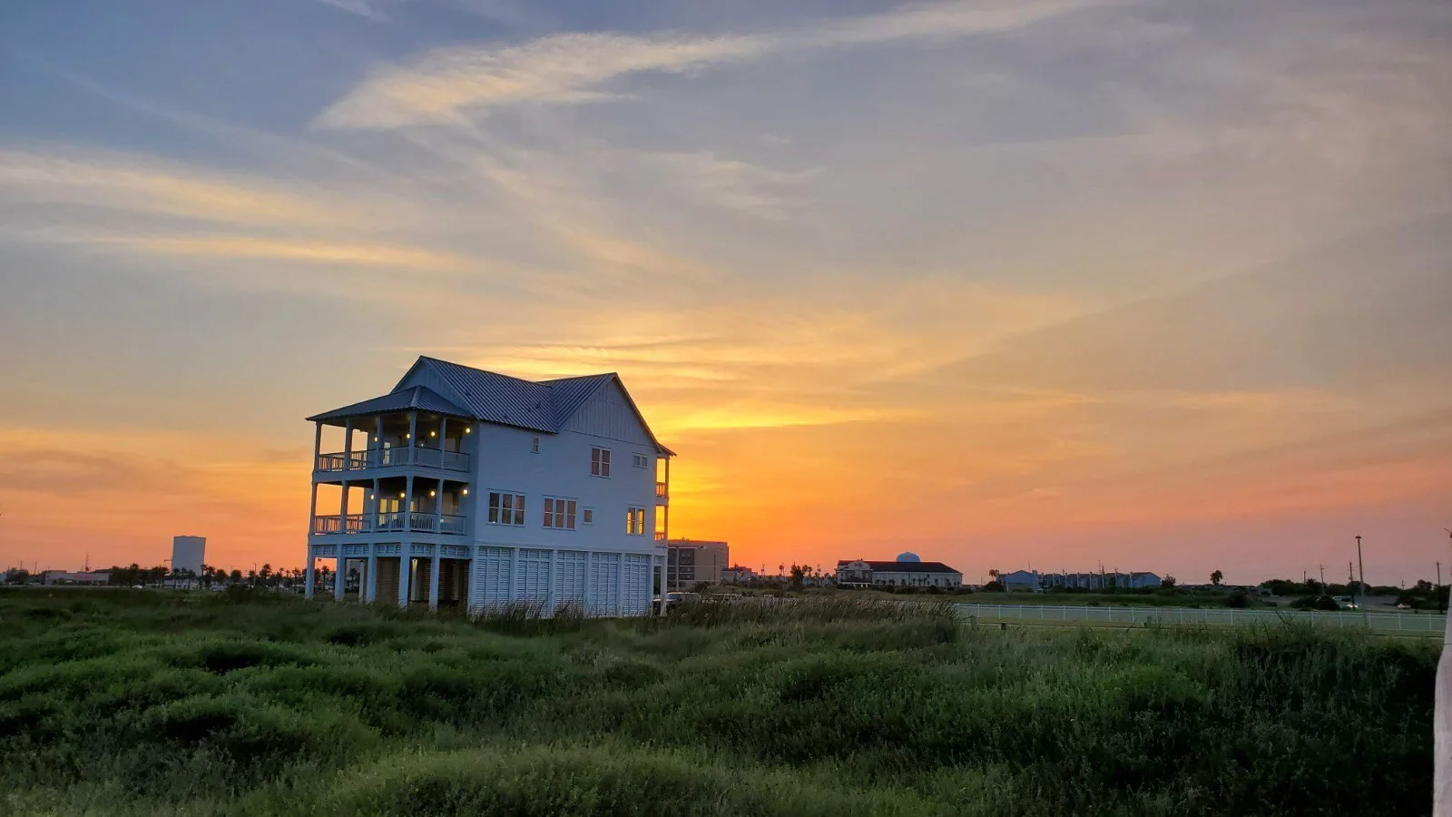 Wilde Dunes beachfront house beneath a wide sunset sky
