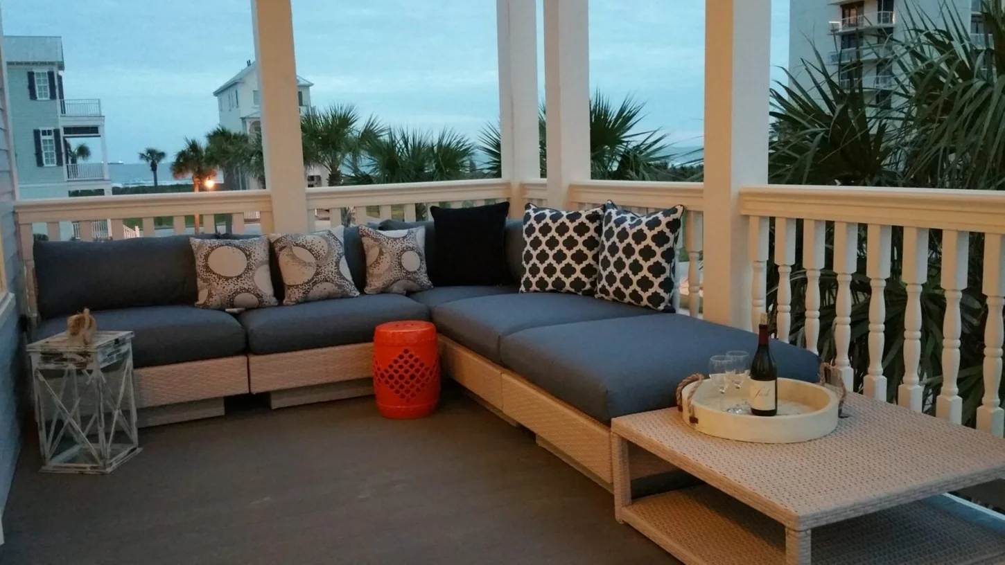 Covered porch at SeaGlass with seating and palm trees